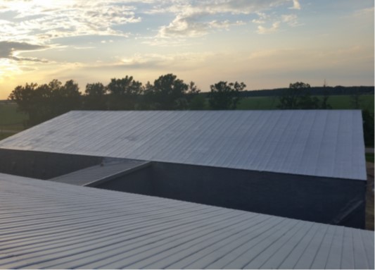 Agricultural steel building with completed roof coating system