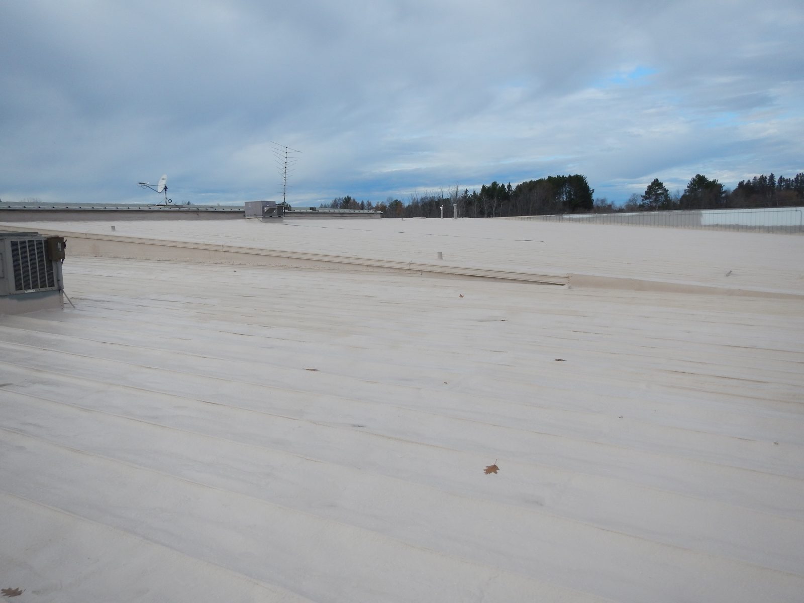 Commercial steel roof during polyurea coating application
